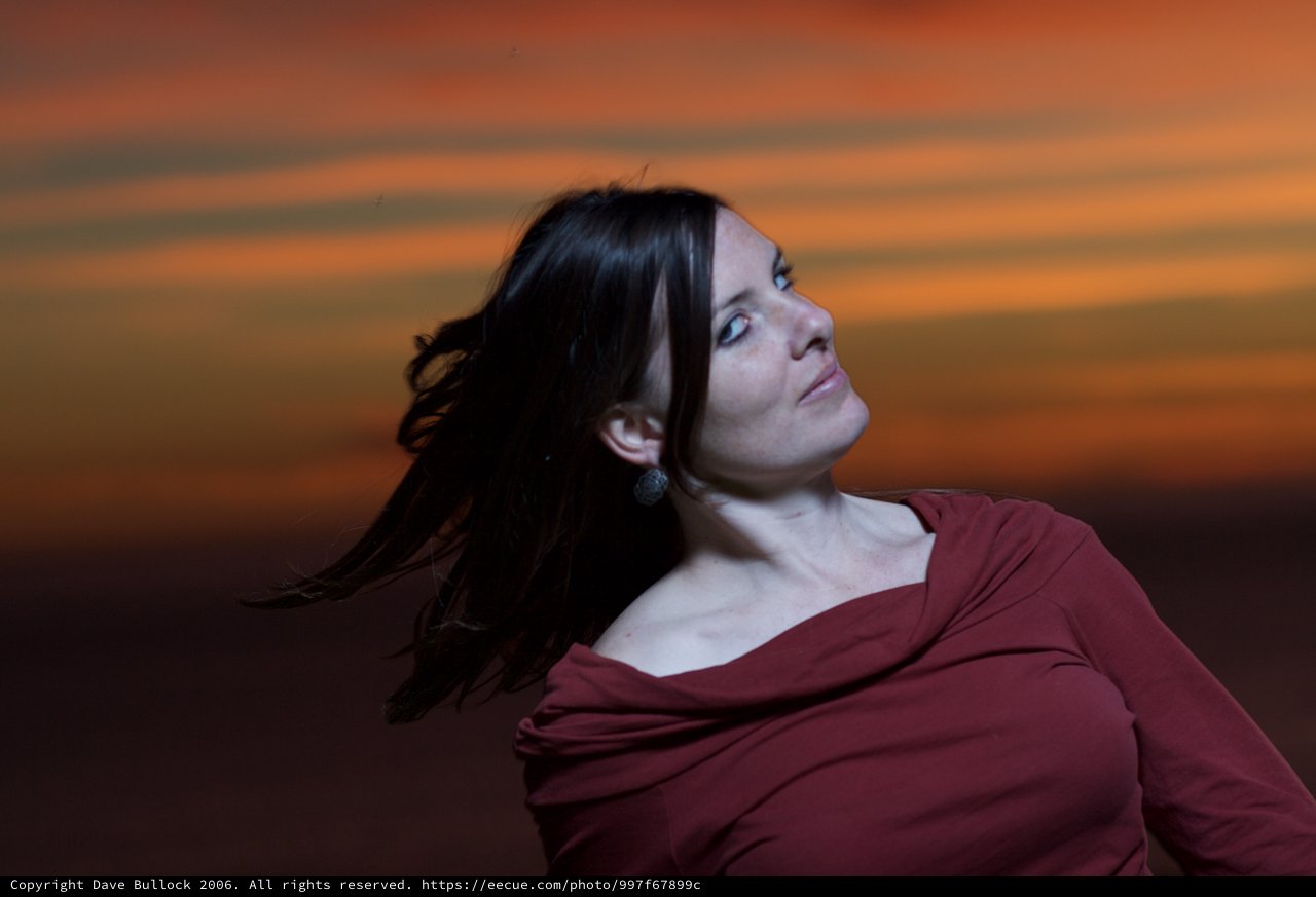 Windswept Woman Against a Fiery Sunset Sky