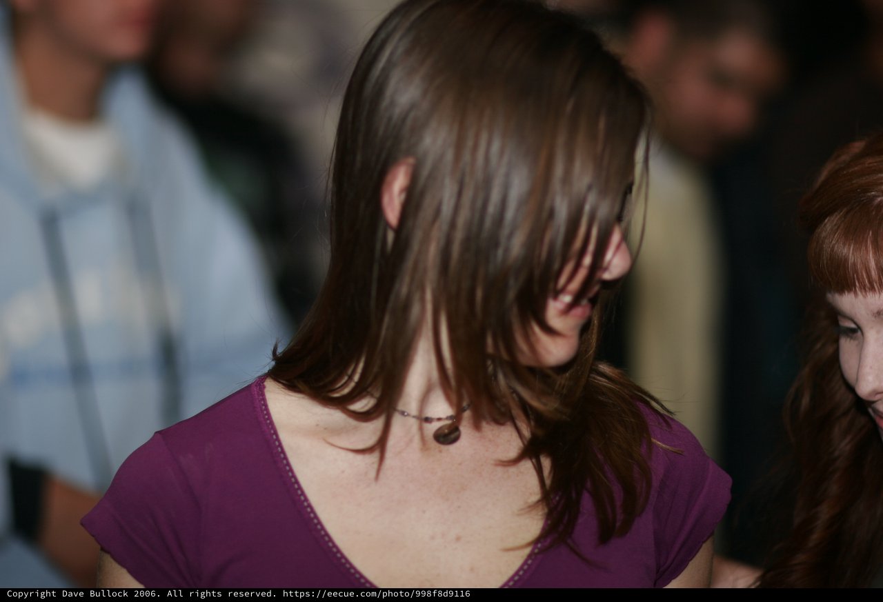 Hair Cascading Over Face at Indoor Gathering