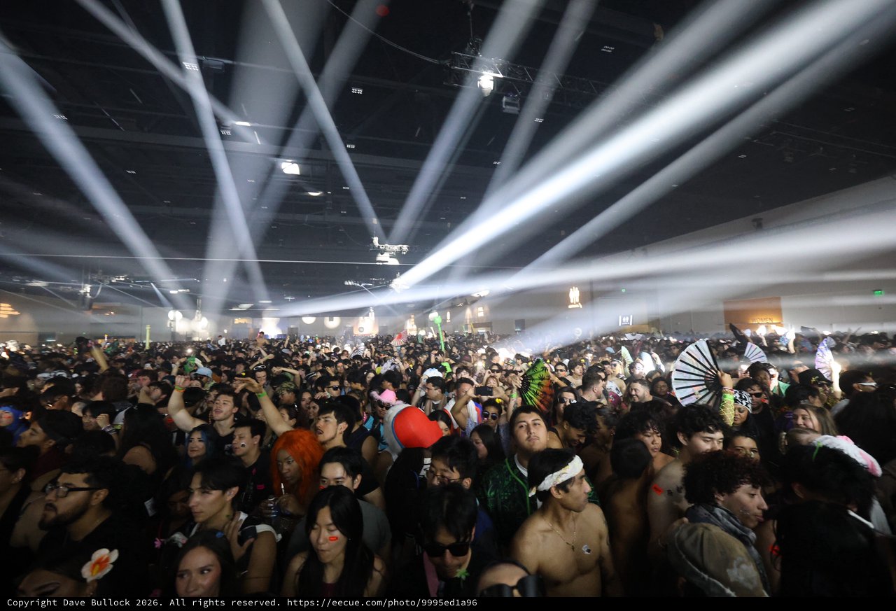 Massive Indoor Rave Crowd Under Dramatic Light Beams