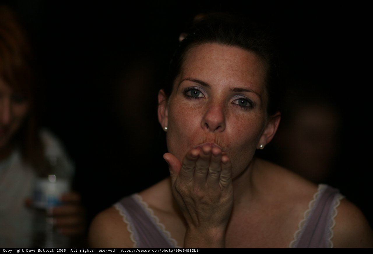Woman Blowing a Kiss at Evening Celebration