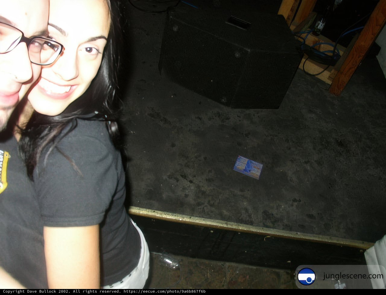Couple in Eyeglasses Poses in Front of Stage