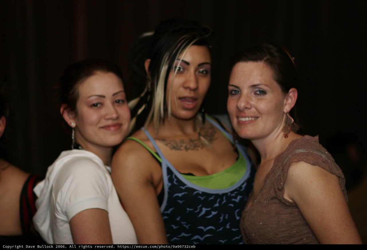 Three Friends Posing Together at Nightclub Event