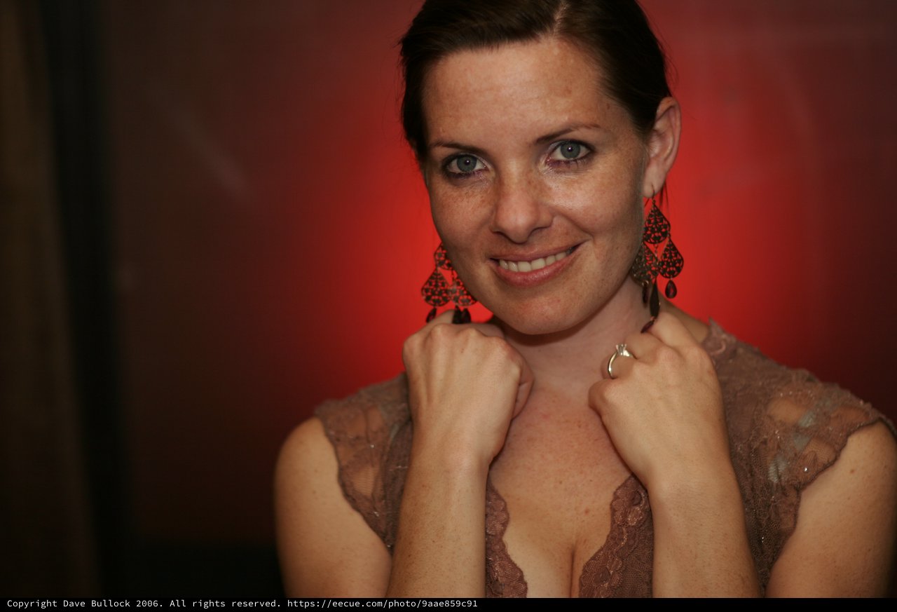 Penelope's Confident Smile Against Bold Red Backdrop