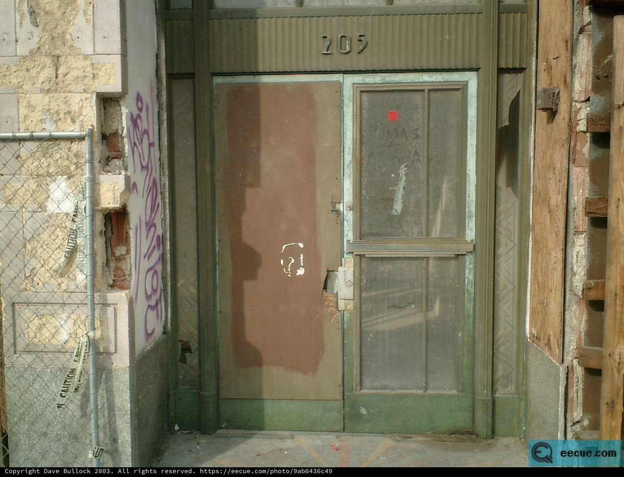 A Door with Bold Graffiti and a Rusted Fence