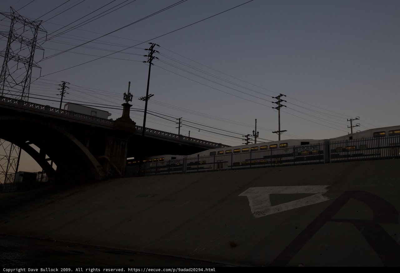 Twilight Train Passing Under Highway Bridge