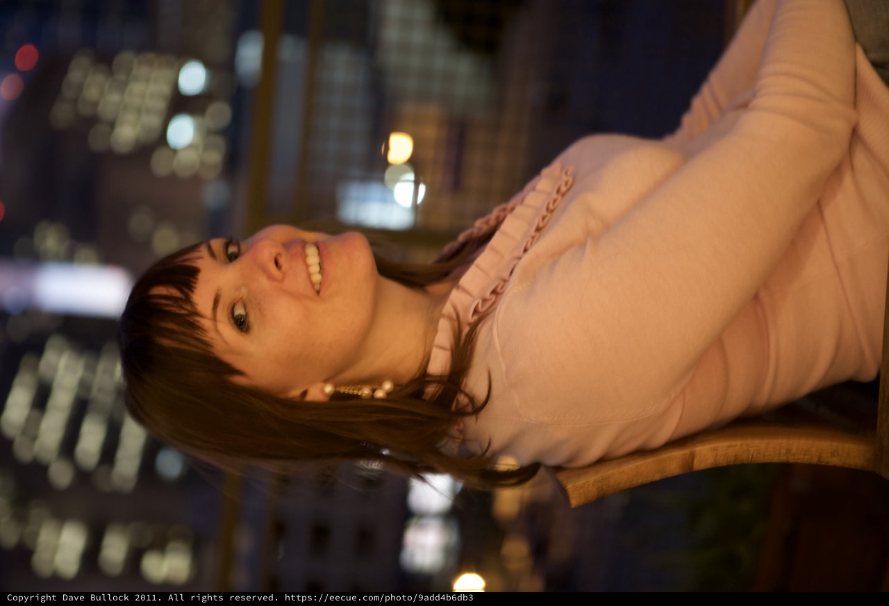 Penelope Smiling Beneath City Lights at Night