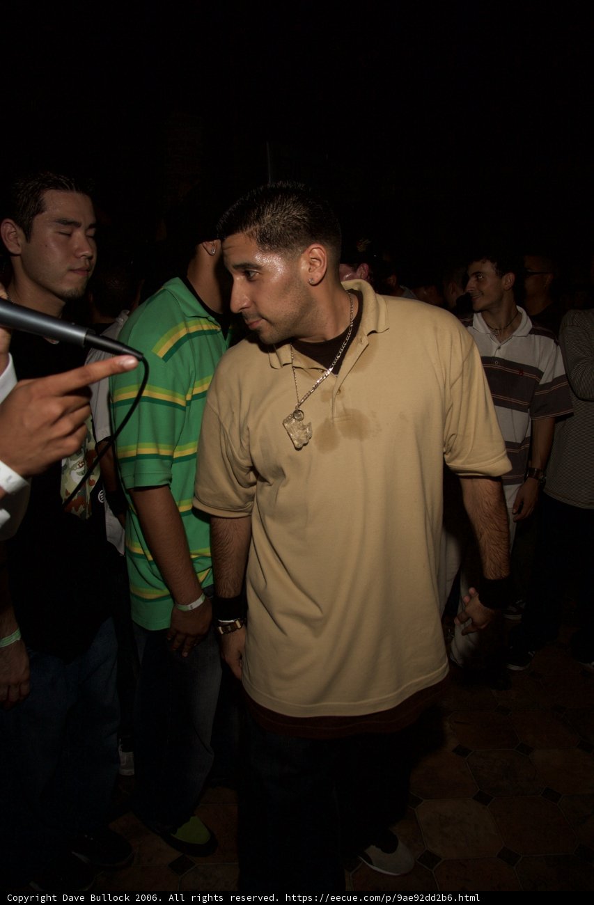 Tan-Shirted Man in an Urban Nightlife Environment