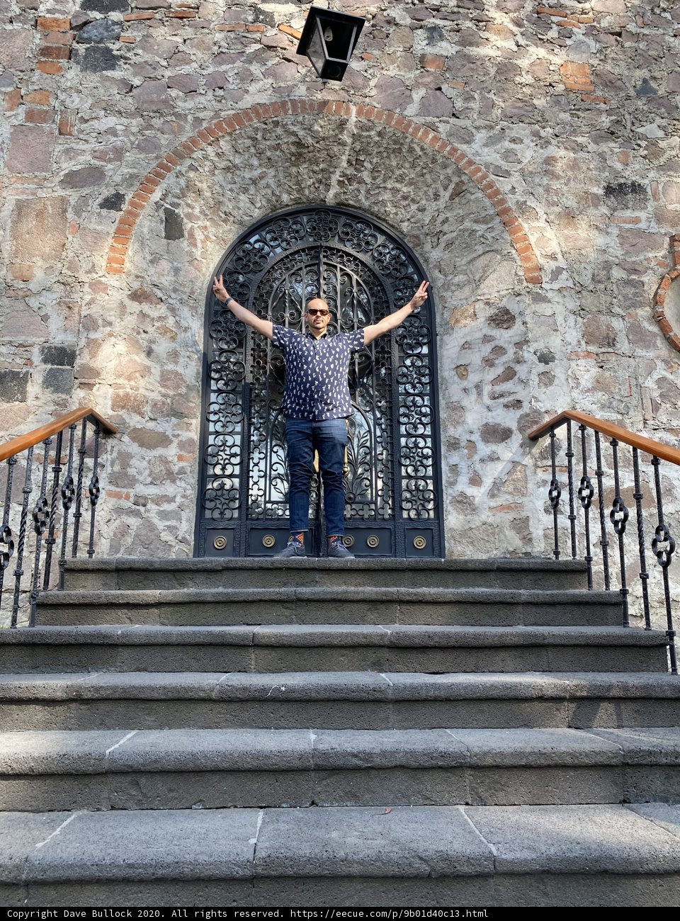 Man in Jeans Standing on Steps of Stone Building