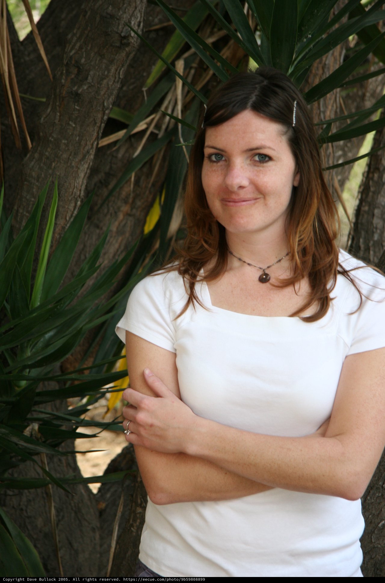 Woman Smiling Beside Tropical Tree Outdoors