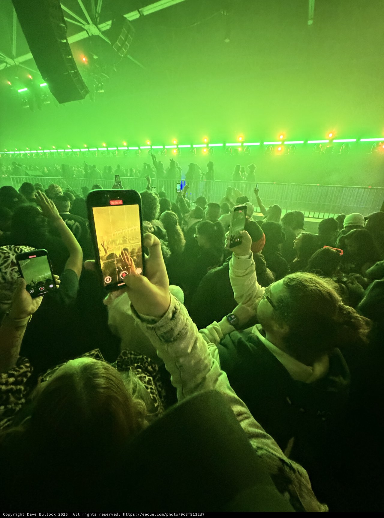 Concert Crowd Recording Performance with Green Stage Lights