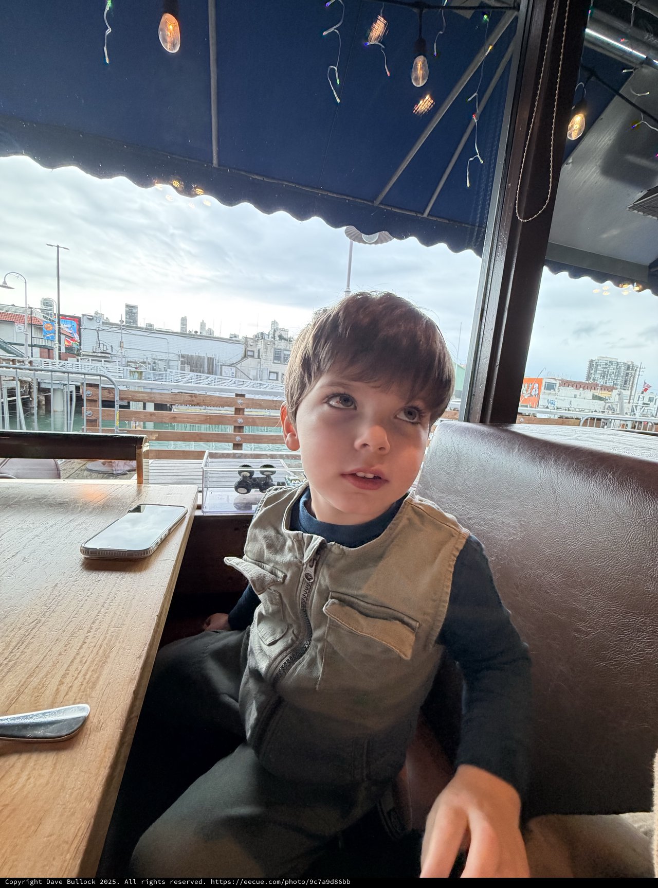 Young Boy at Rooftop Restaurant with City Views