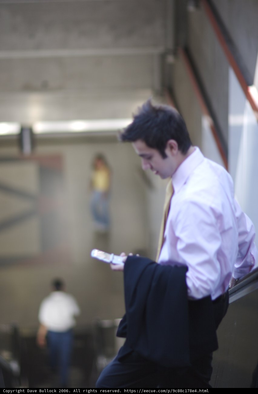 Pink Shirted Man Holding a Phone and Handgun
