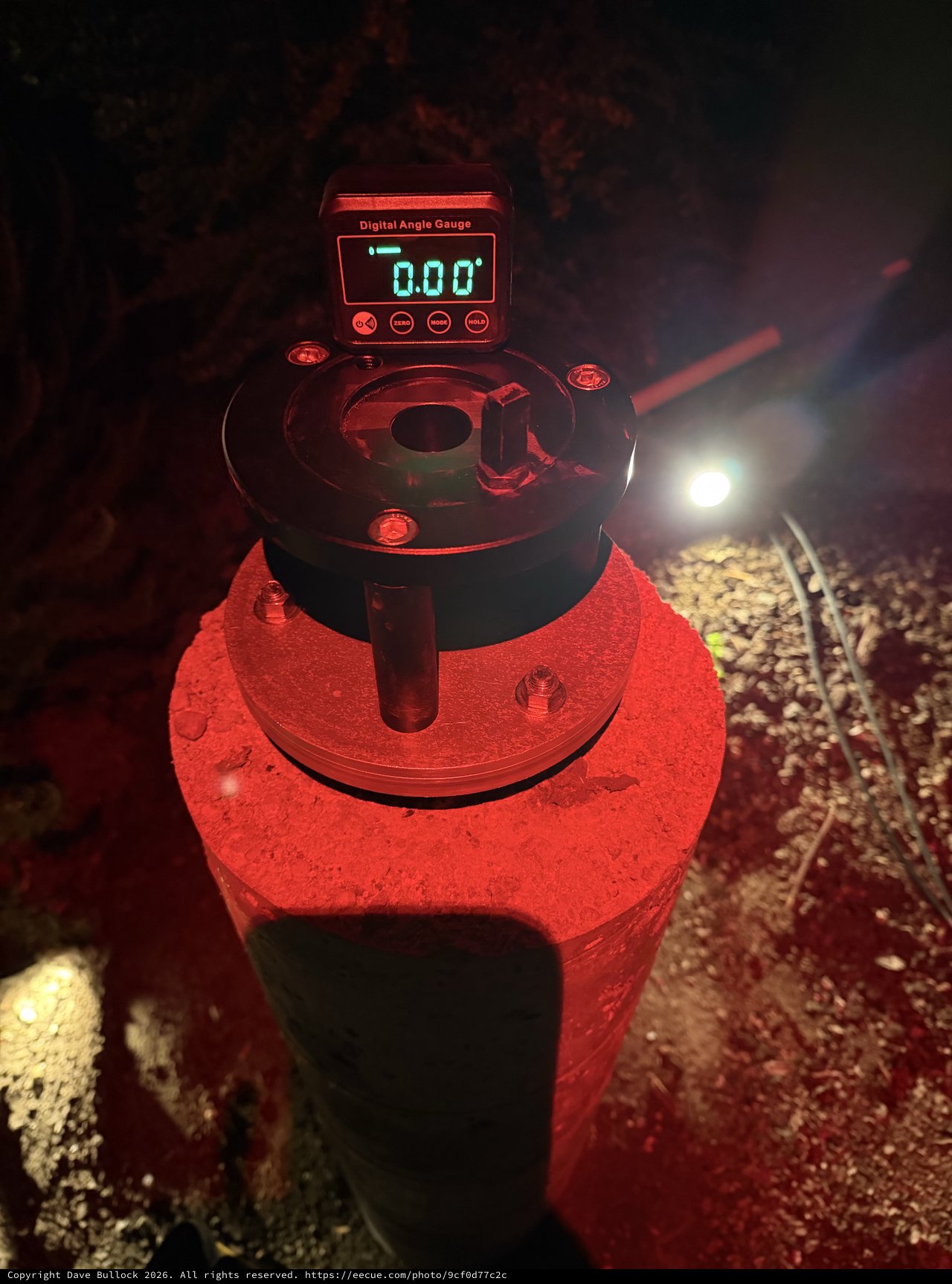 Digital Angle Gauge Zeroed on Red Concrete Pier at Night
