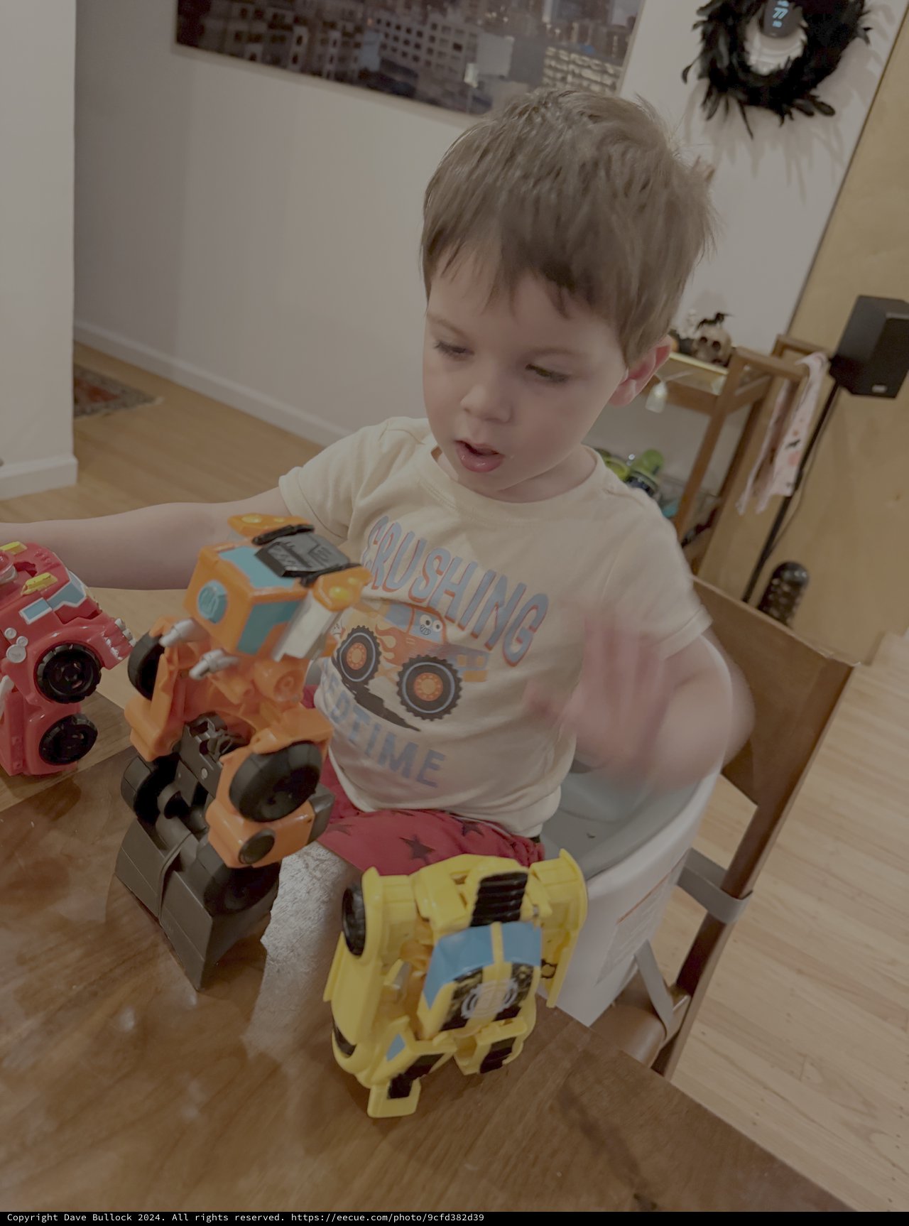 Young Boy Playing with Colorful Toy Trucks