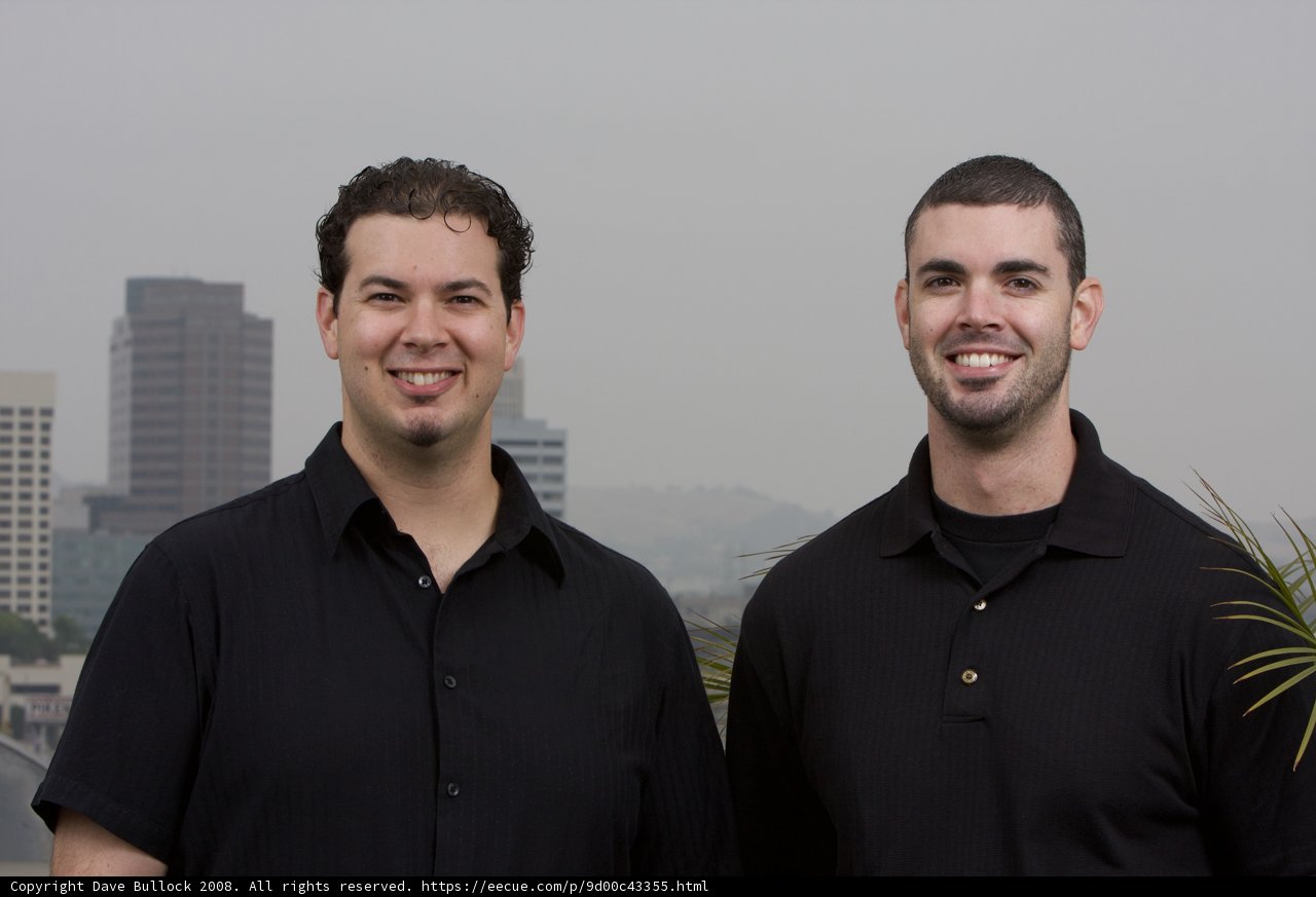 Two Men Posed in Front of a Cityscape