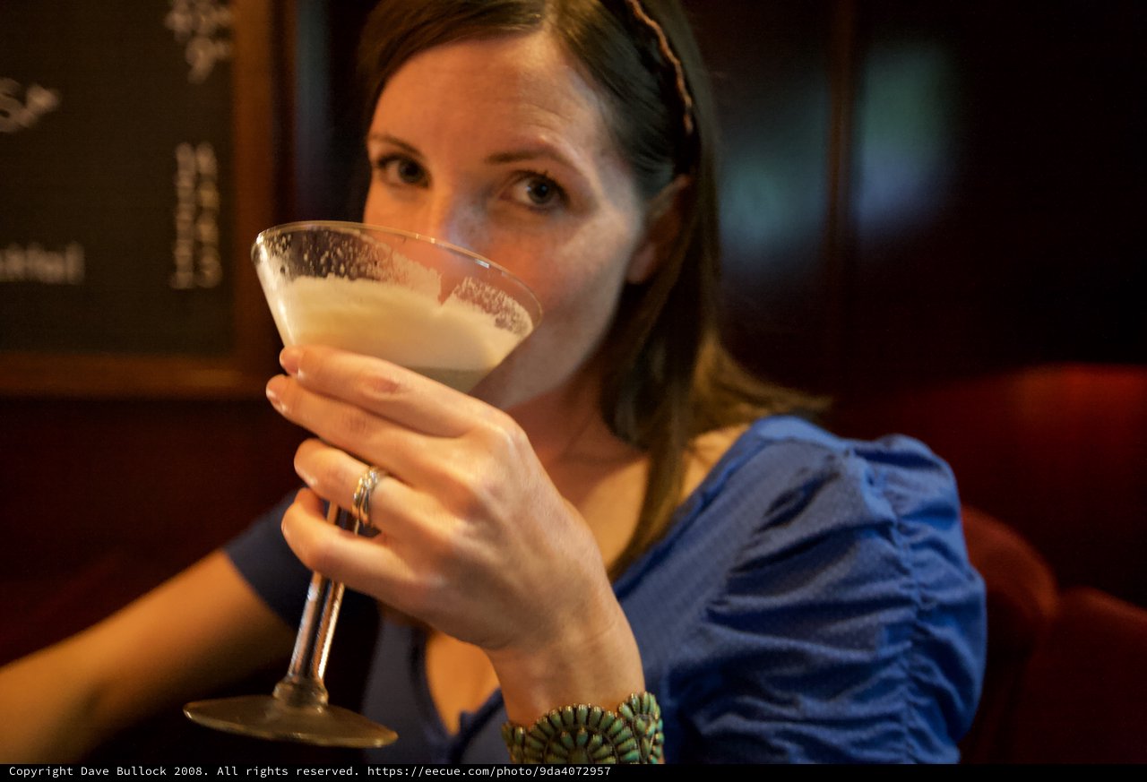 Woman Sipping Creamy Cocktail at Upscale Bar