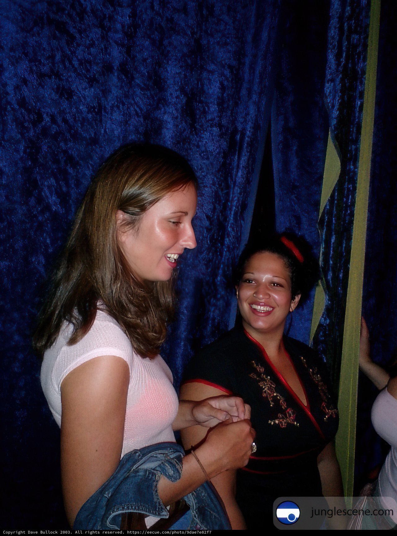 Smiling Women in Front of Blue Curtain