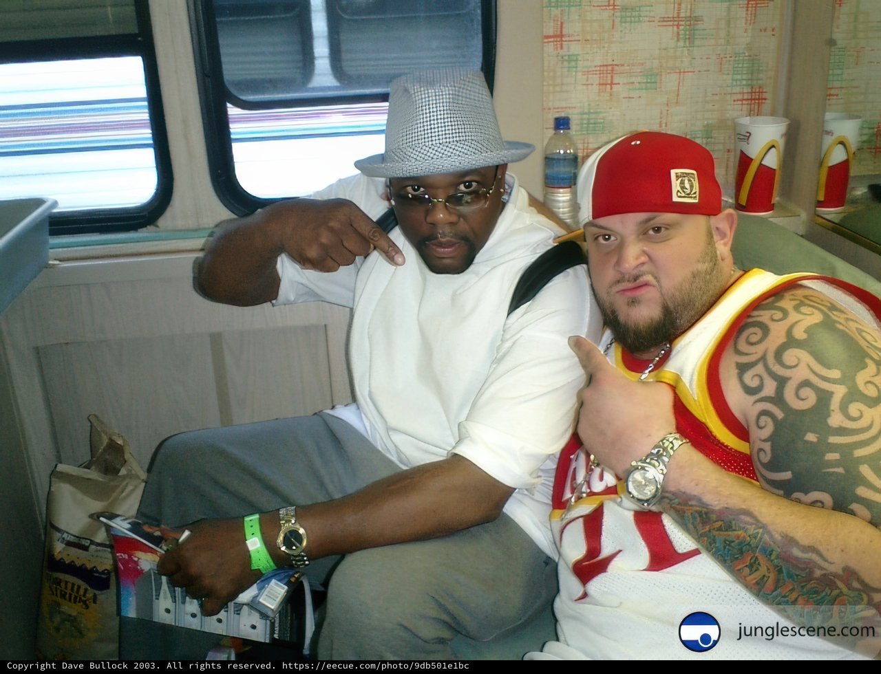 Two Men on a Bus with Tattoos and Accessories