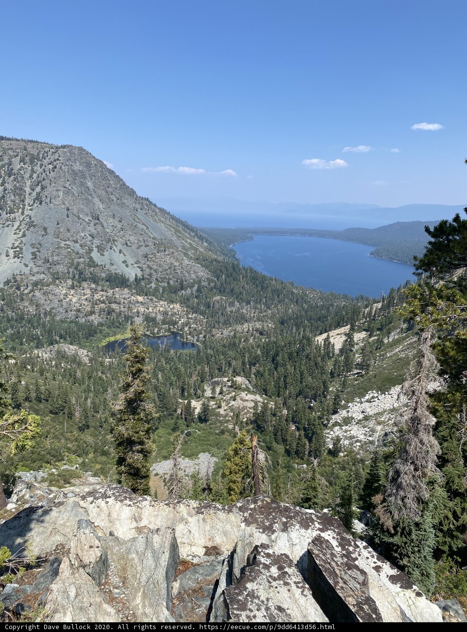 Serene View of Lake and Mountains from Rocky Hillside