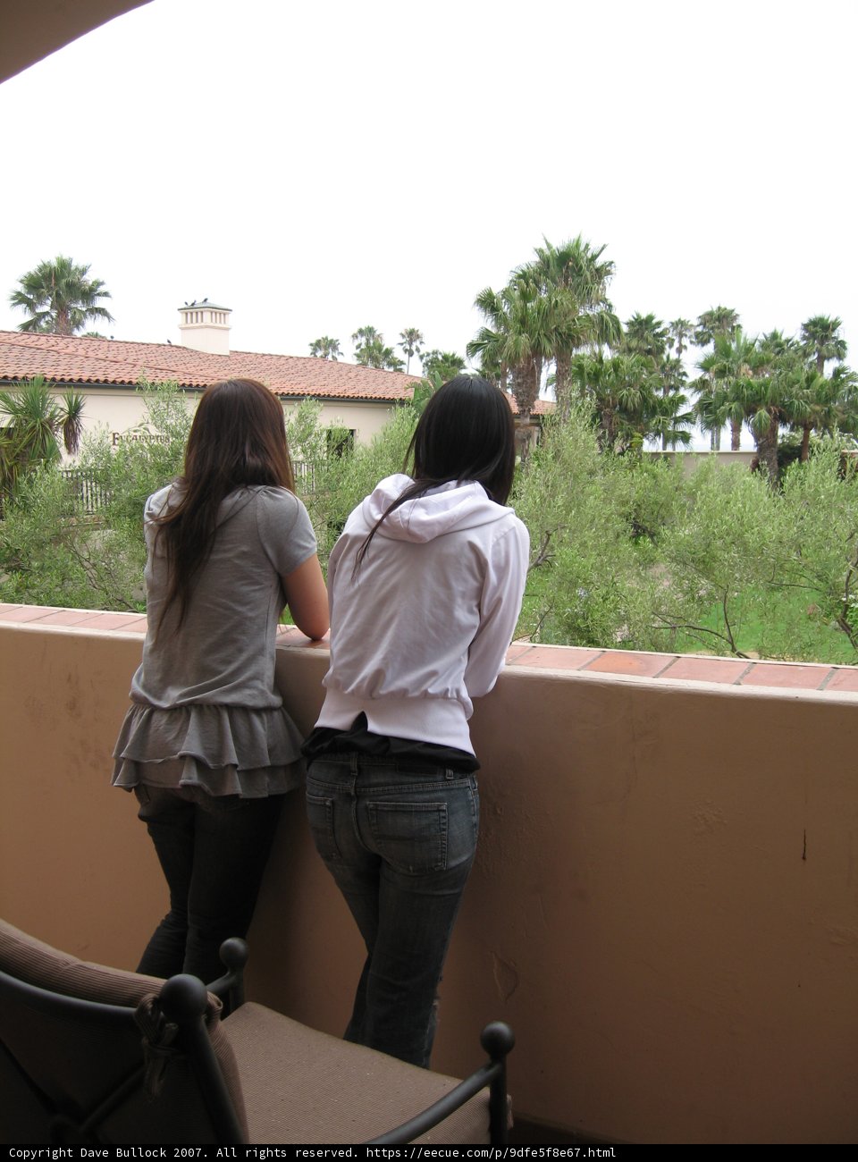 Relaxing on the Balcony Caption: Two women enjoying the stunning view while wearing comfortable jeans and blouses during a wine tasting event in 2007.