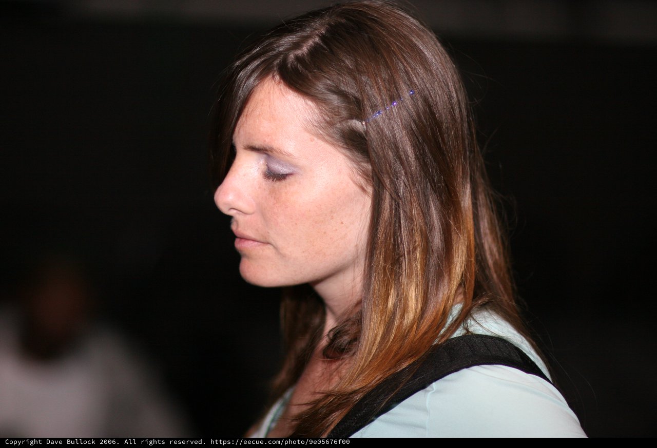 Contemplative Woman in Profile at Dark Venue