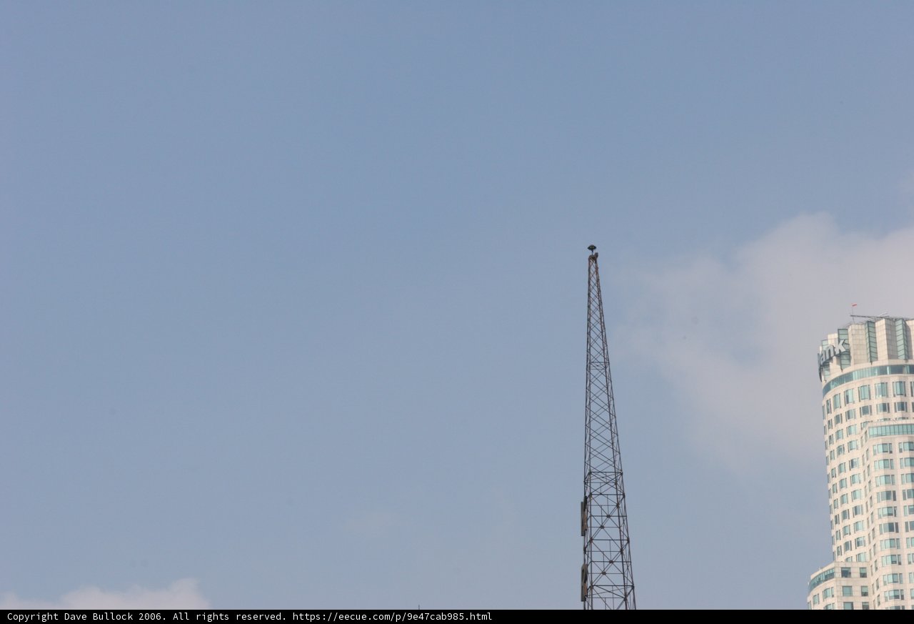 Towering Skyscraper with Radio Tower and Construction Crane