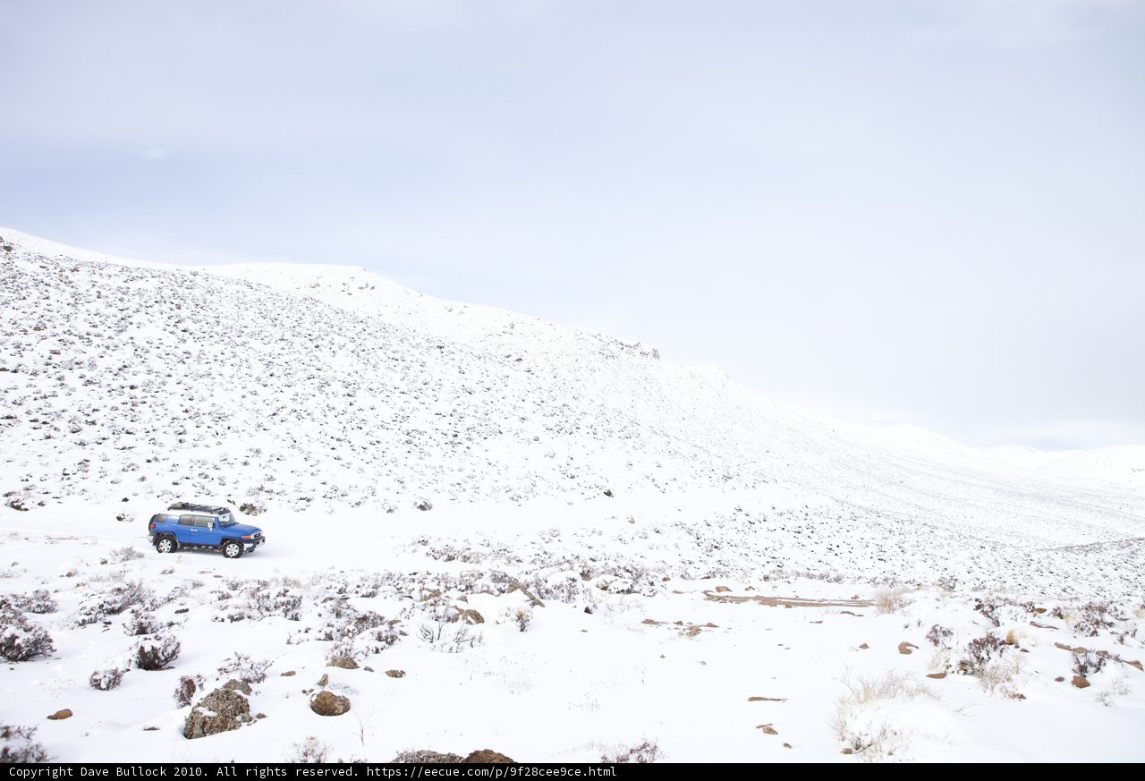 Blue Car on Snowy Slope