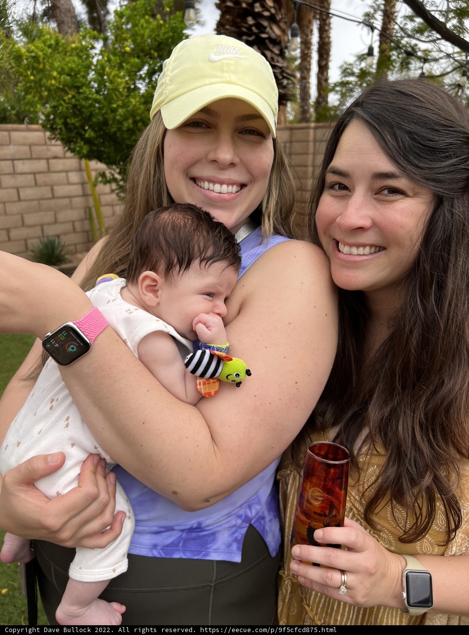 Two Women Bask in the Joy of Holding a Newborn Baby Outdoors
