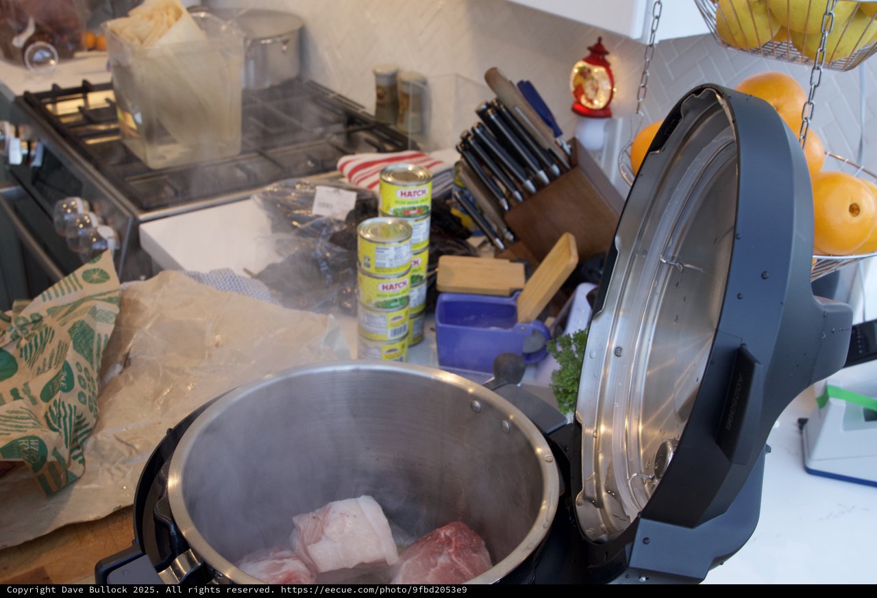 Pressure Cooker with Raw Meat on Cluttered Kitchen Counter