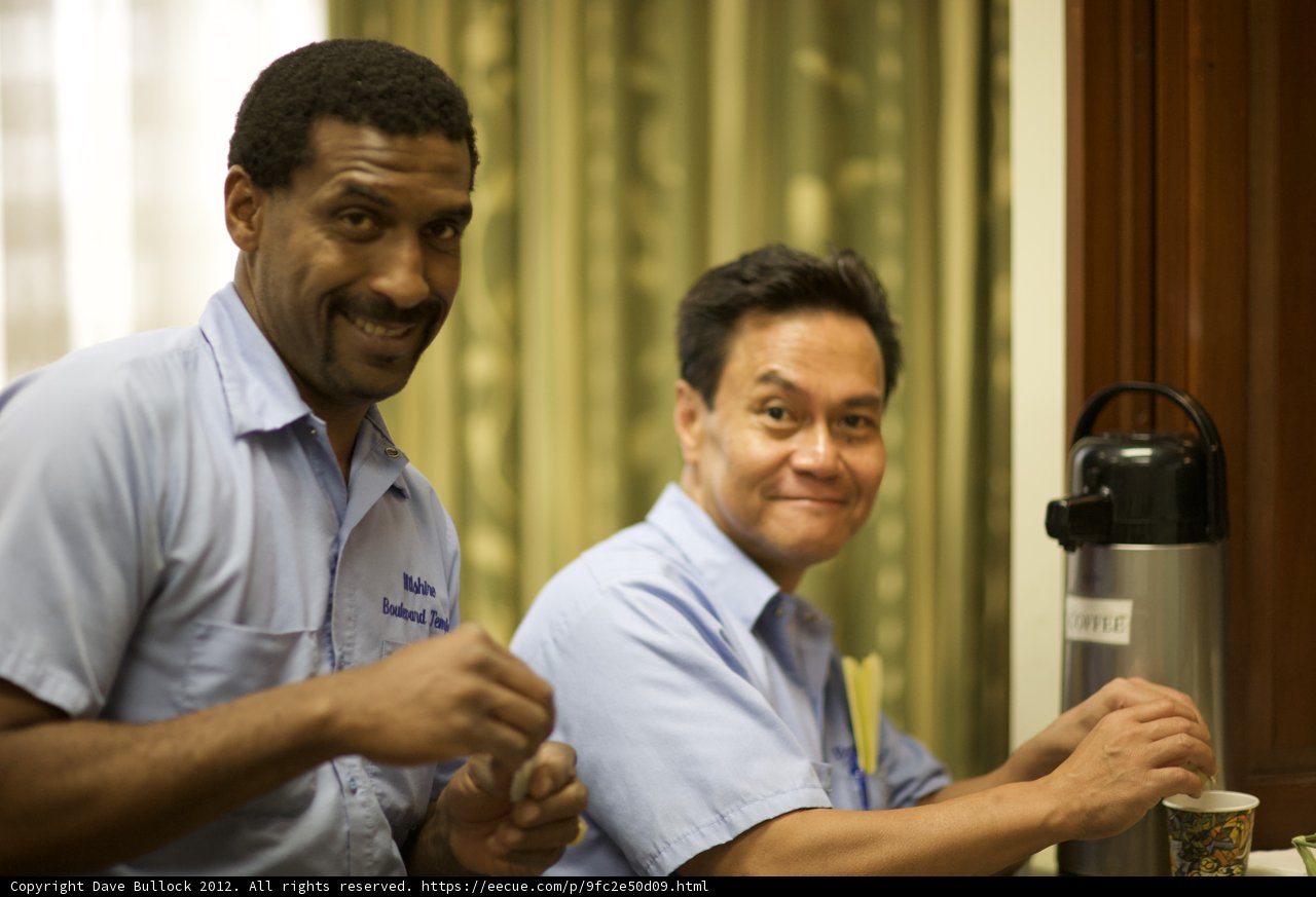 Two Men in Blue Shirts Enjoying Drinks