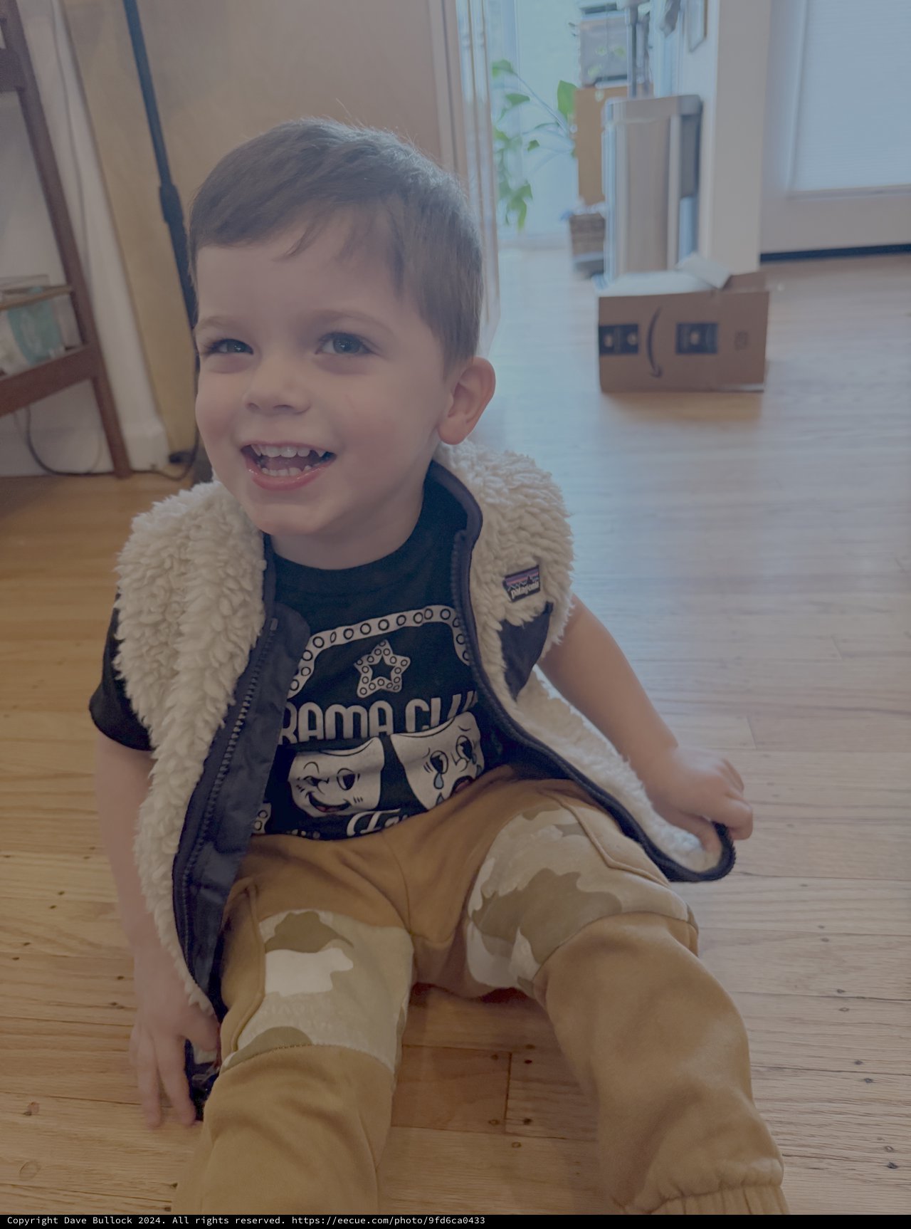 Happy Toddler in Sherpa Vest Playing at Home