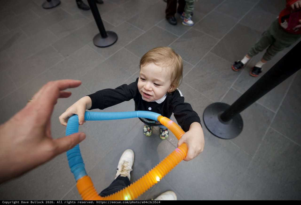 Toddler Playing with Colorful Tubes at Baby Rave Event