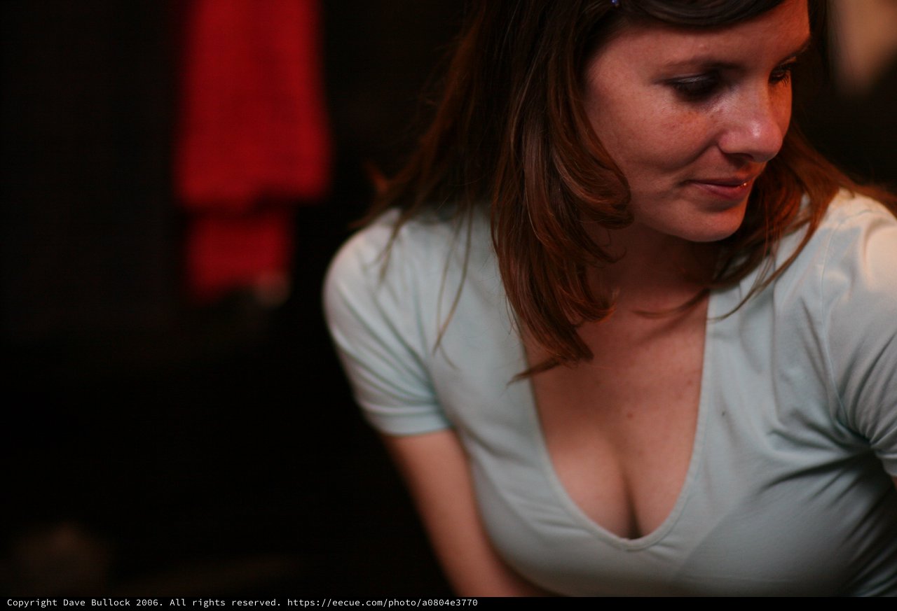 Woman in White V-Neck Shirt at Dimly Lit Venue