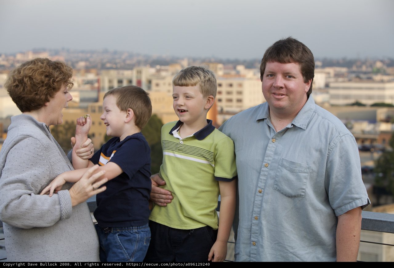 Family Portrait on Rooftop Overlooking City Skyline