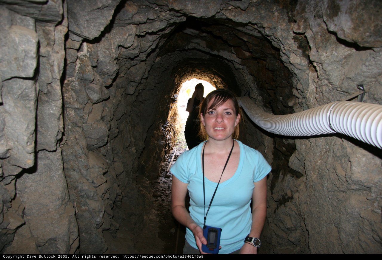 Explorer Poses Inside Ancient Rock Mine Tunnel
