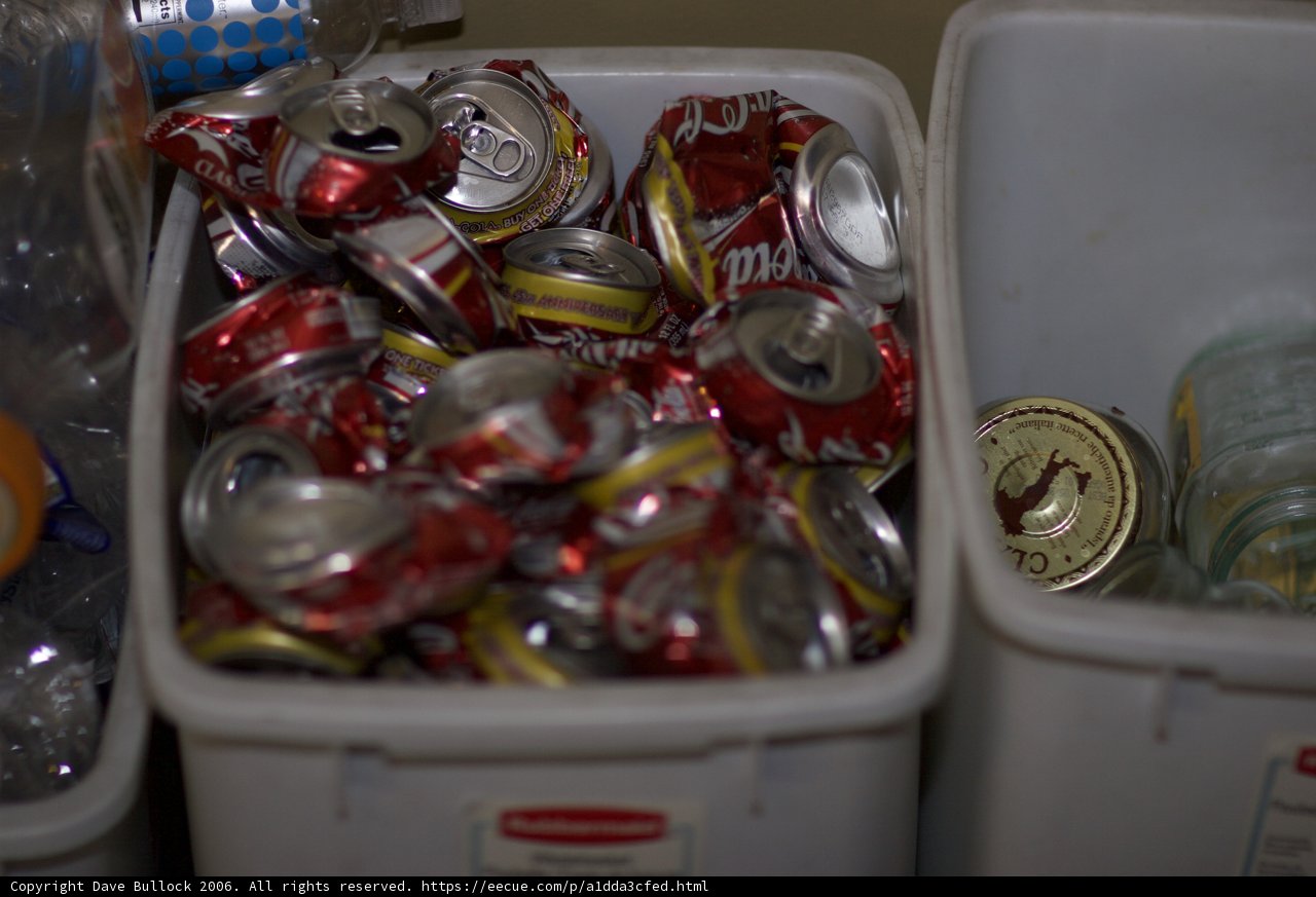Recycling Bin Overflowing with Empty Soda Cans