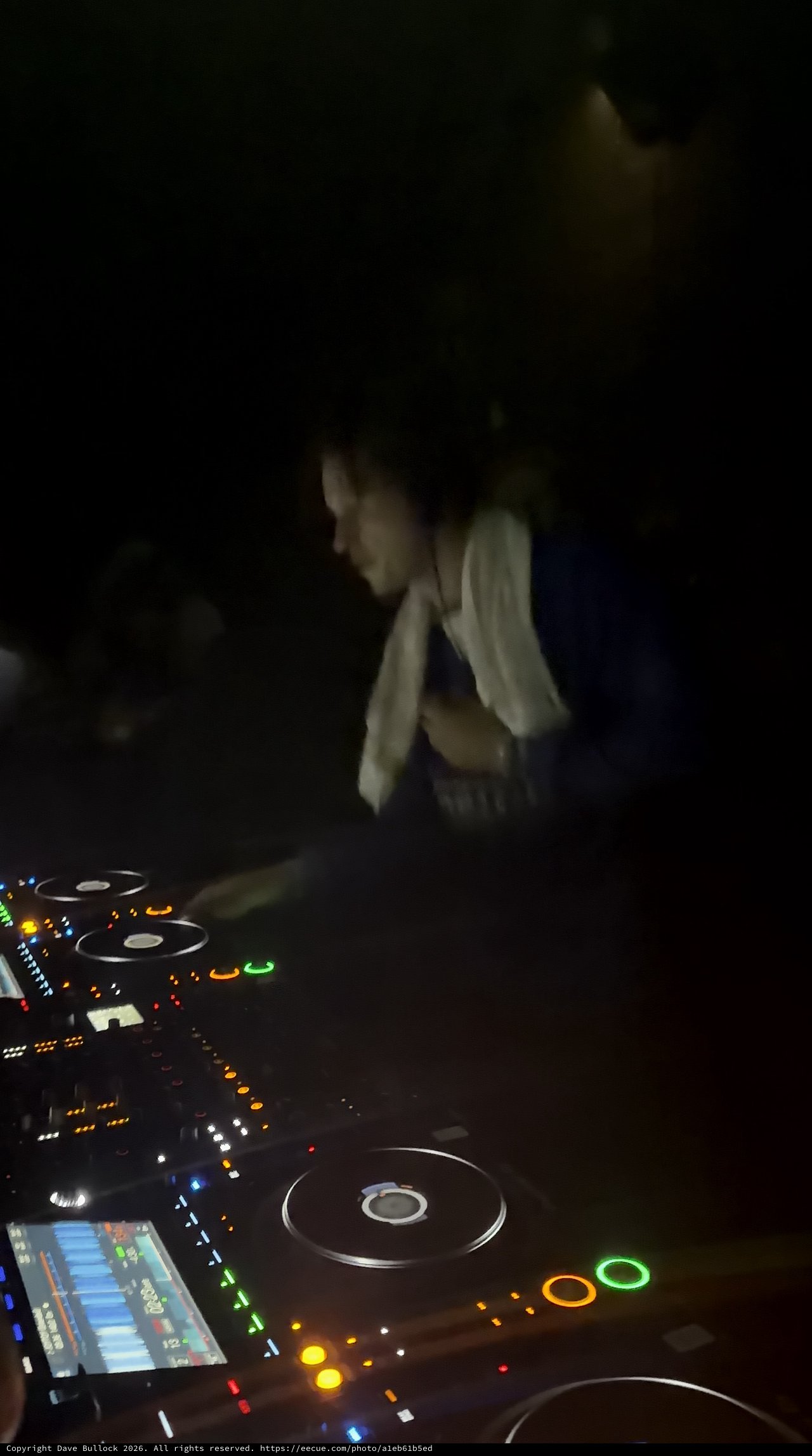DJ at Work Behind Illuminated CDJ Decks in London