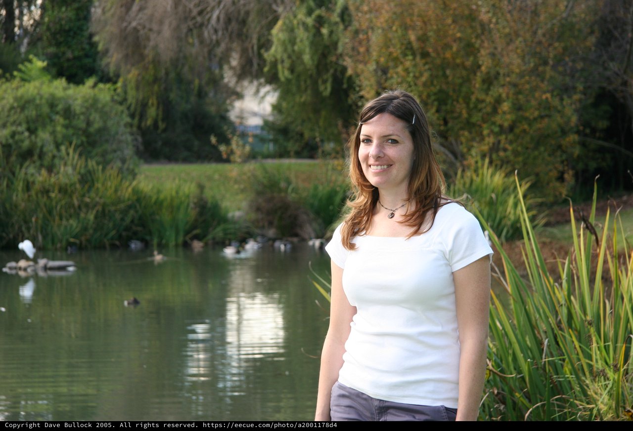 Smiling Woman by a Tranquil Park Pond