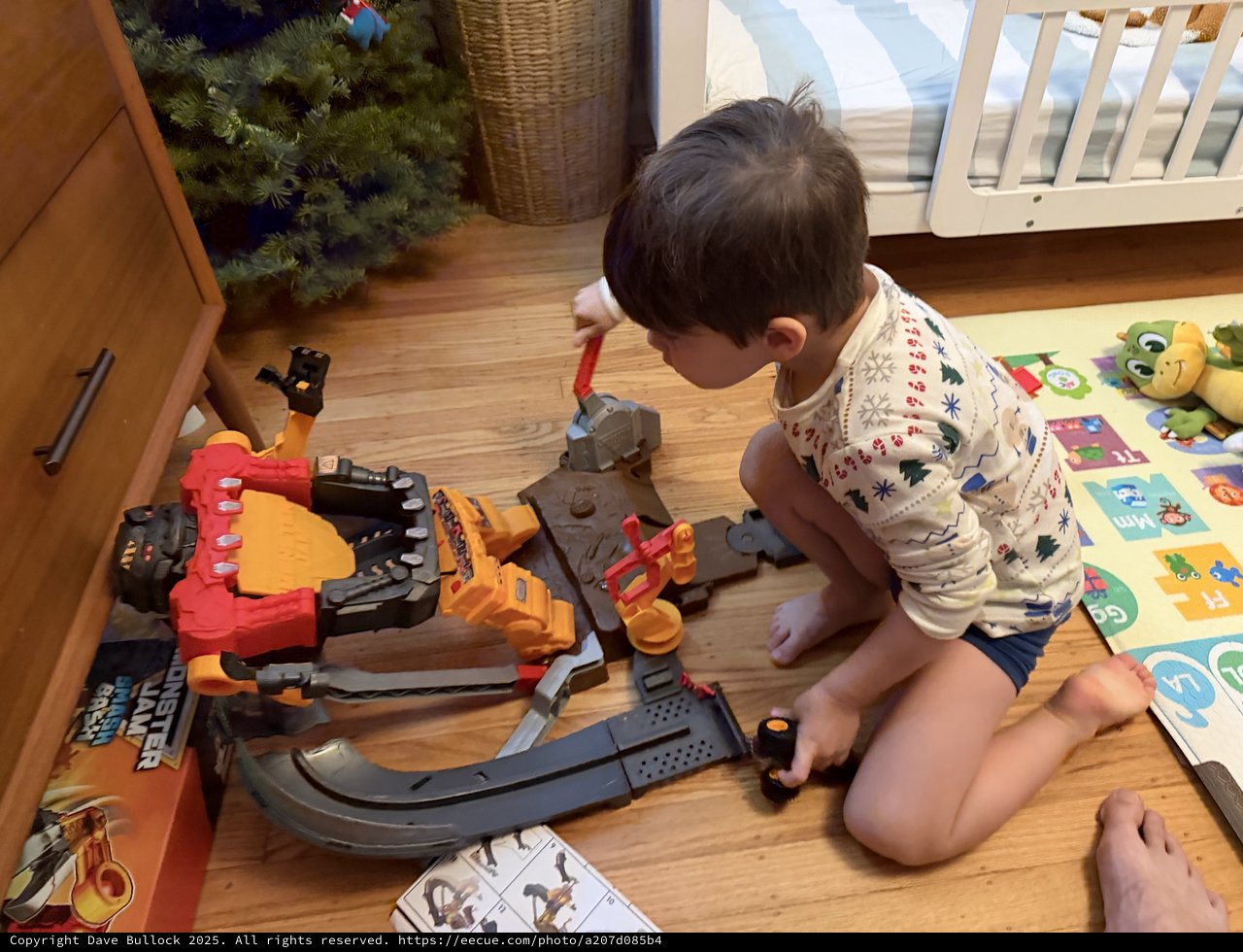 Young Boy Playing with Monster Truck Toy Set at Home
