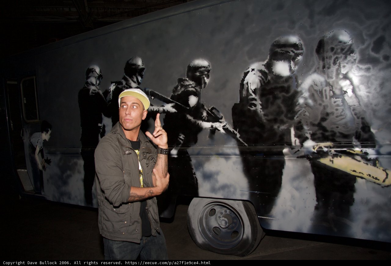 Gun-wielding Man in Front of a Mural
