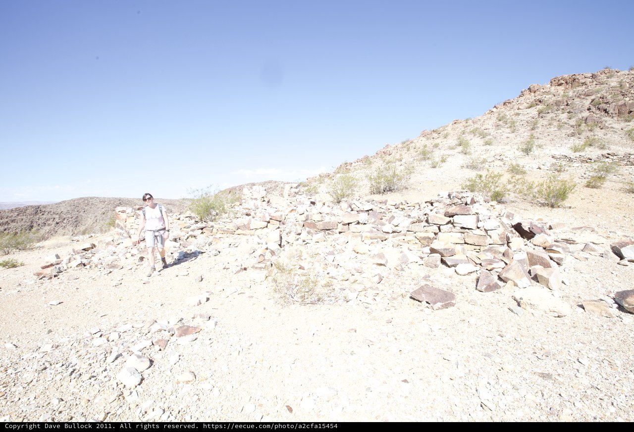 Desert Hiker Explores Ancient Stone Ruins in Arid Landscape