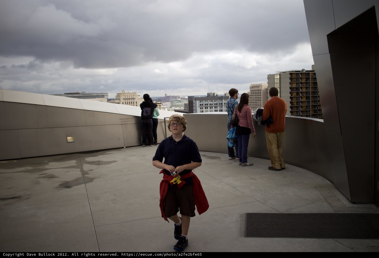 Young Boy on Urban Rooftop Observation Deck