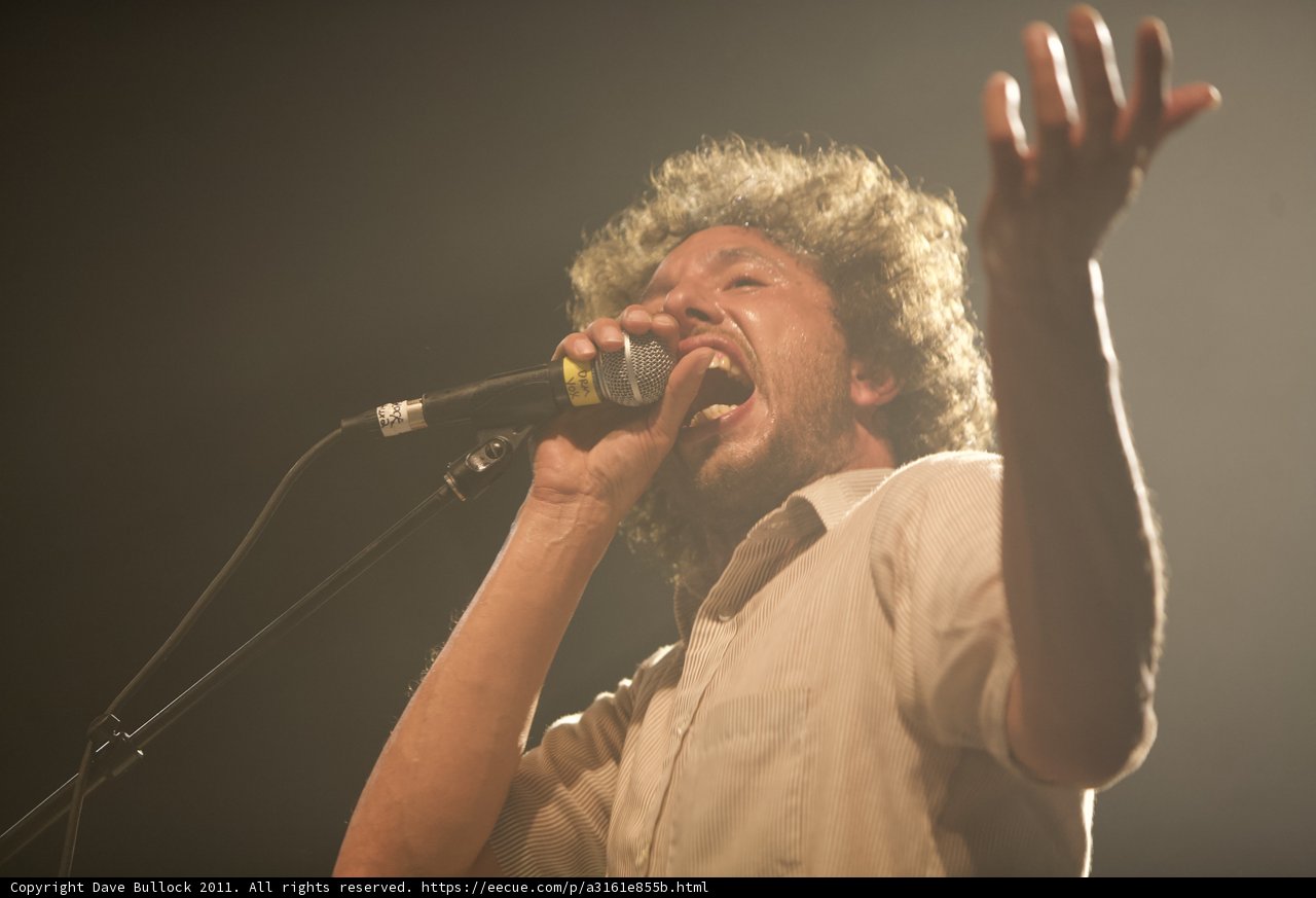 Solo Performance: Man with Curly Hair Singing into a Microphone