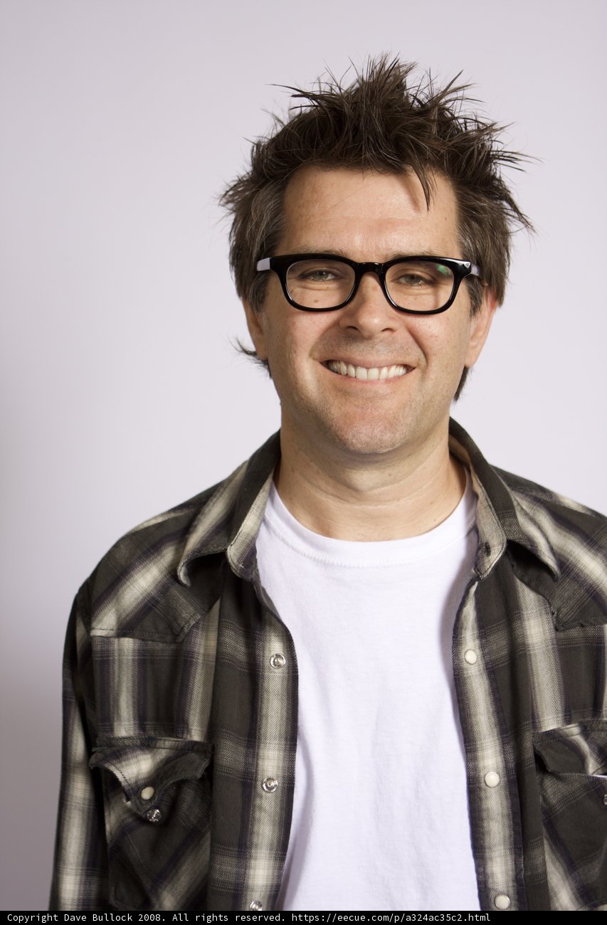 Smiling Man in Plaid Shirt and Glasses