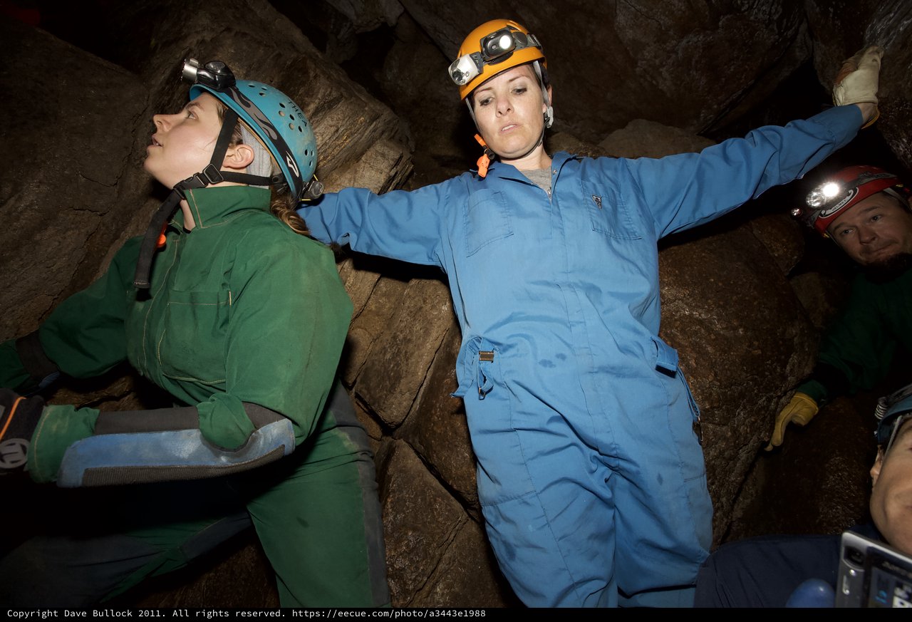 Cavers Navigate Tight Underground Passage in Cave