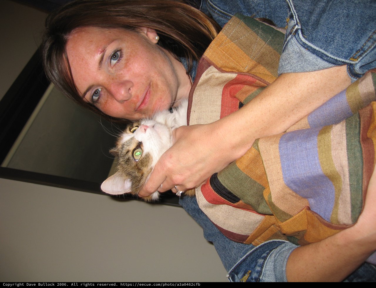 Woman Cuddling Tabby Kitten with Affectionate Smile