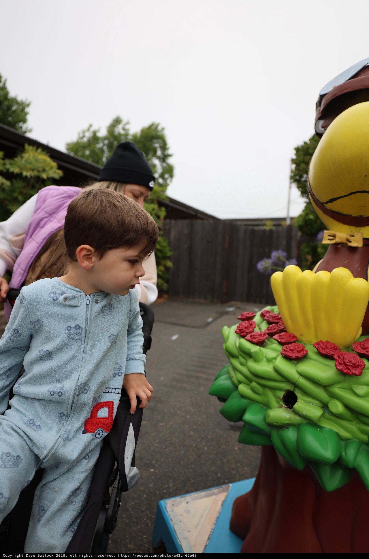 Curious Child Examines Colorful Festival Statue Up Close
