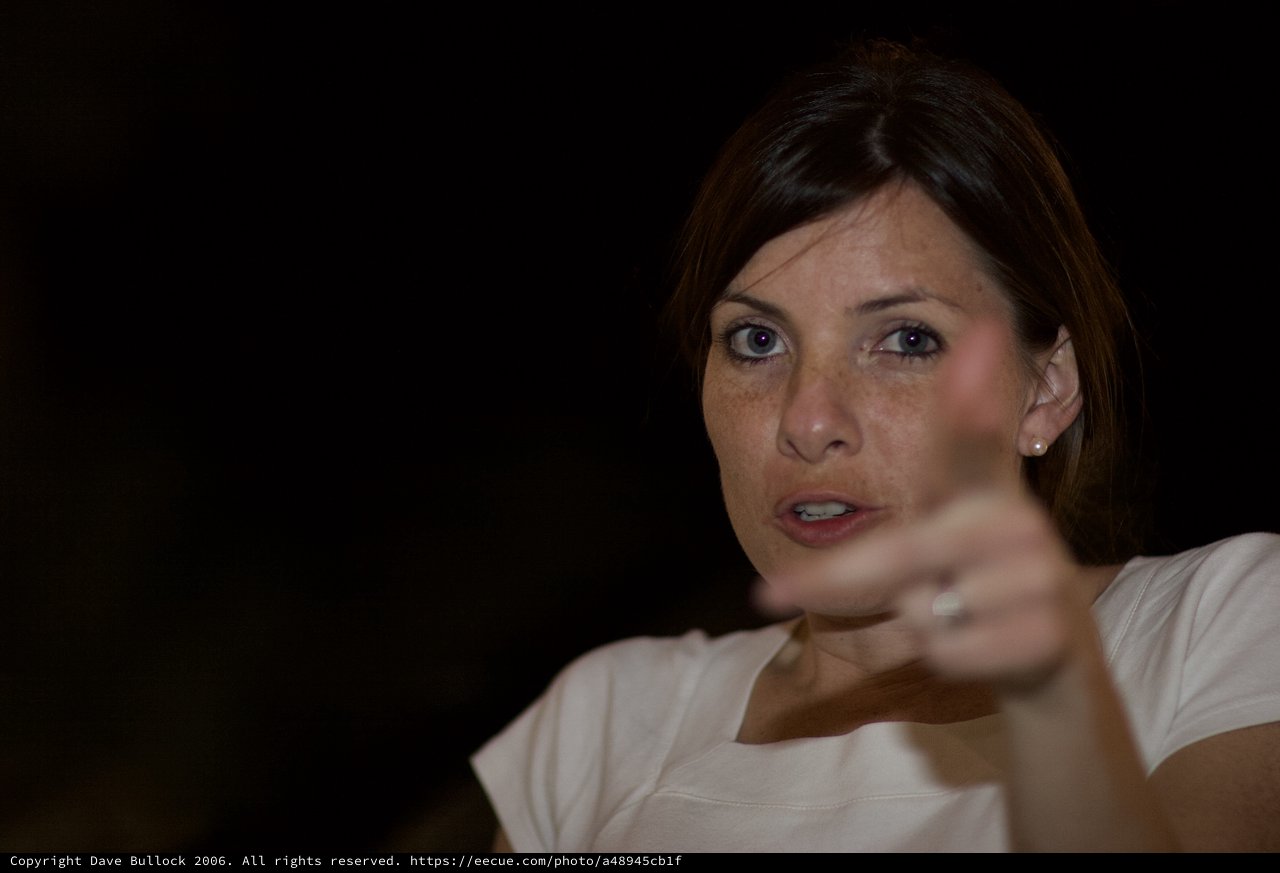 Woman Gesturing Expressively Against Dark Background