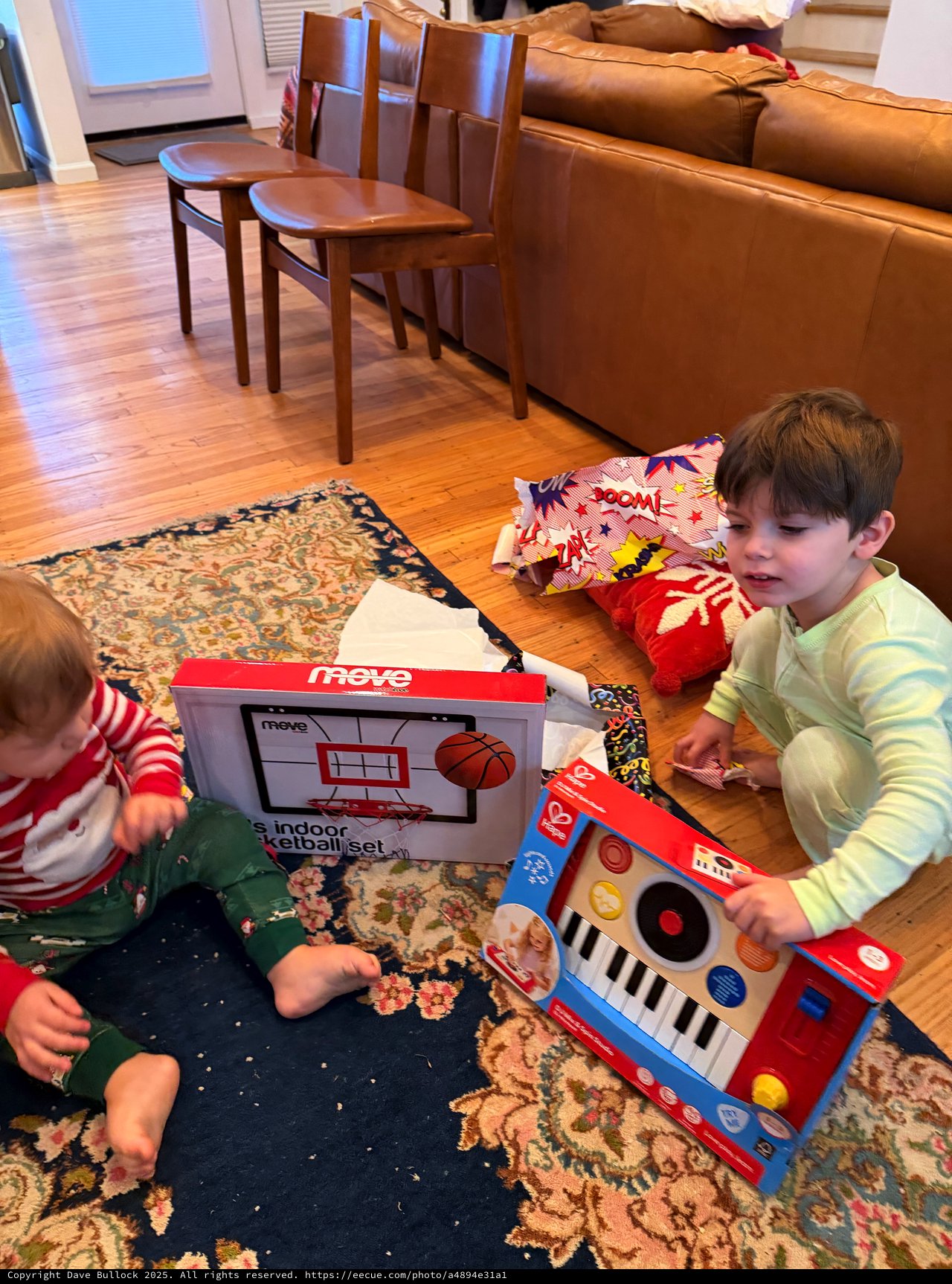 Children Opening Christmas Gifts in Cozy Living Room