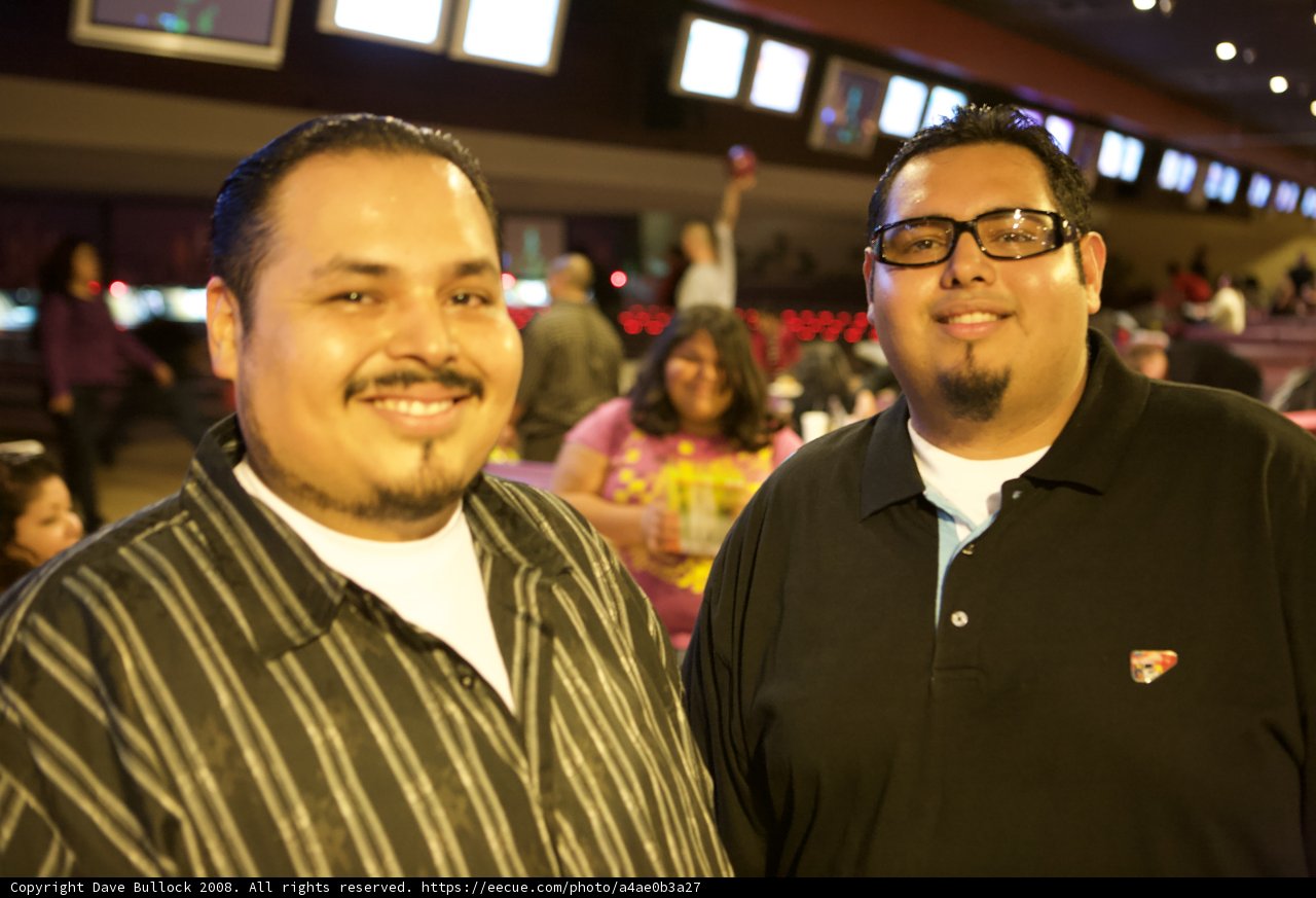 Two Men Smiling with Glasses at APC Christmas Party